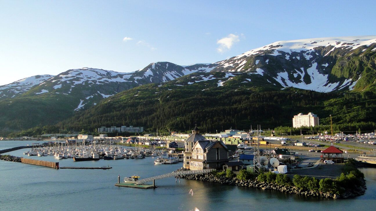 A landscape shot of a town in Alaska with mountains in the background.